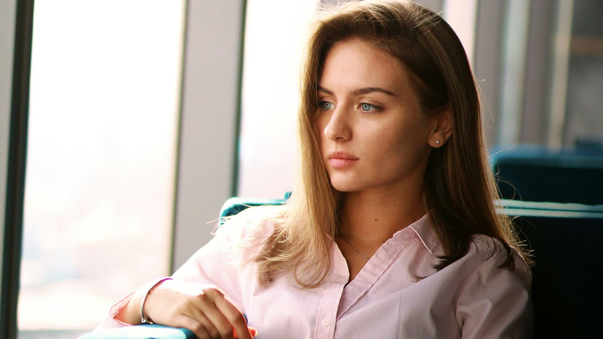 a woman sitting in front of a window