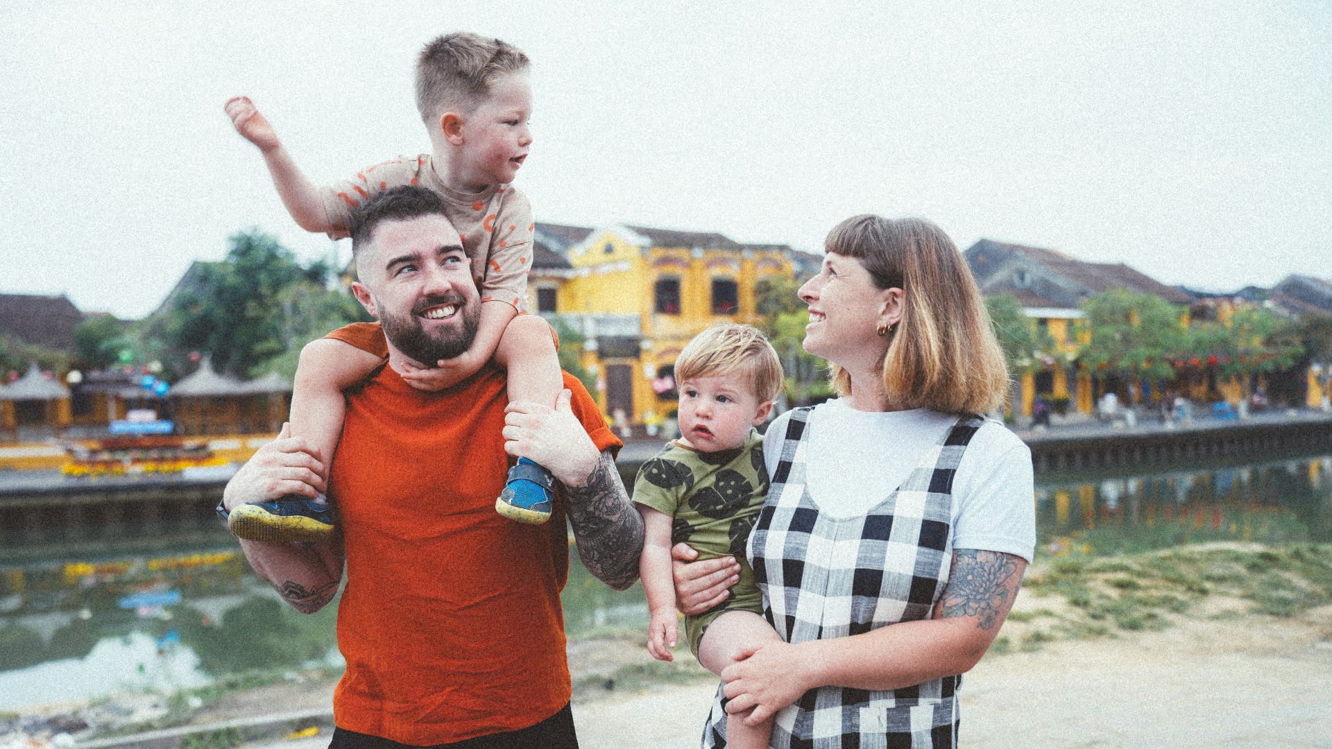 a man holding a child while standing next to two women and a child
