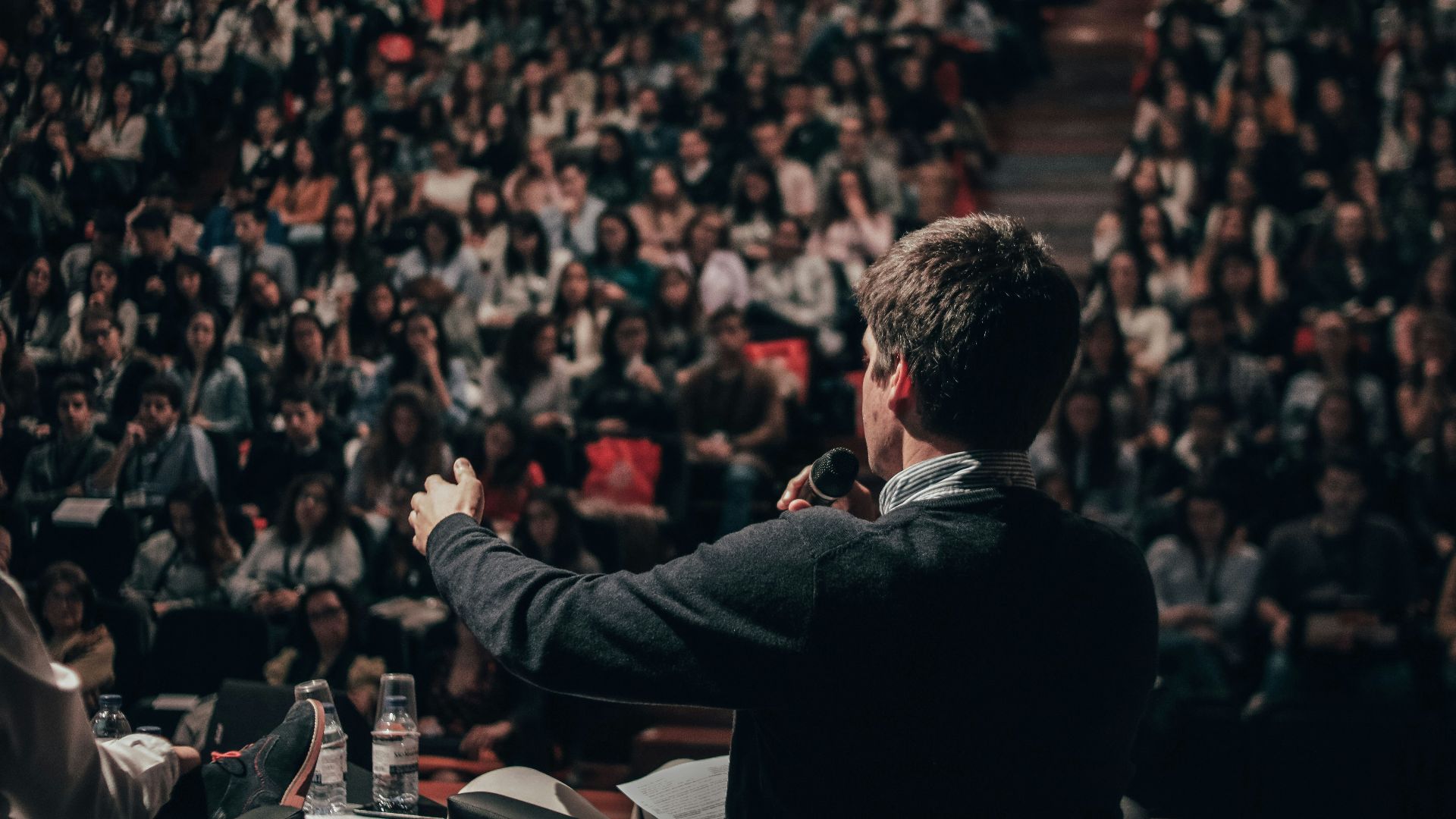 man speaking in front of crowd