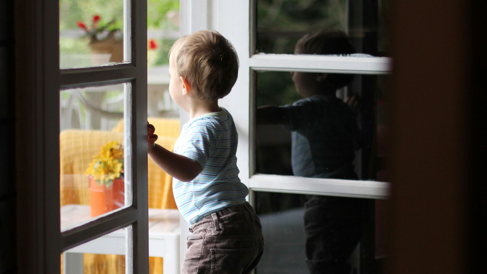 toddler standing beside door