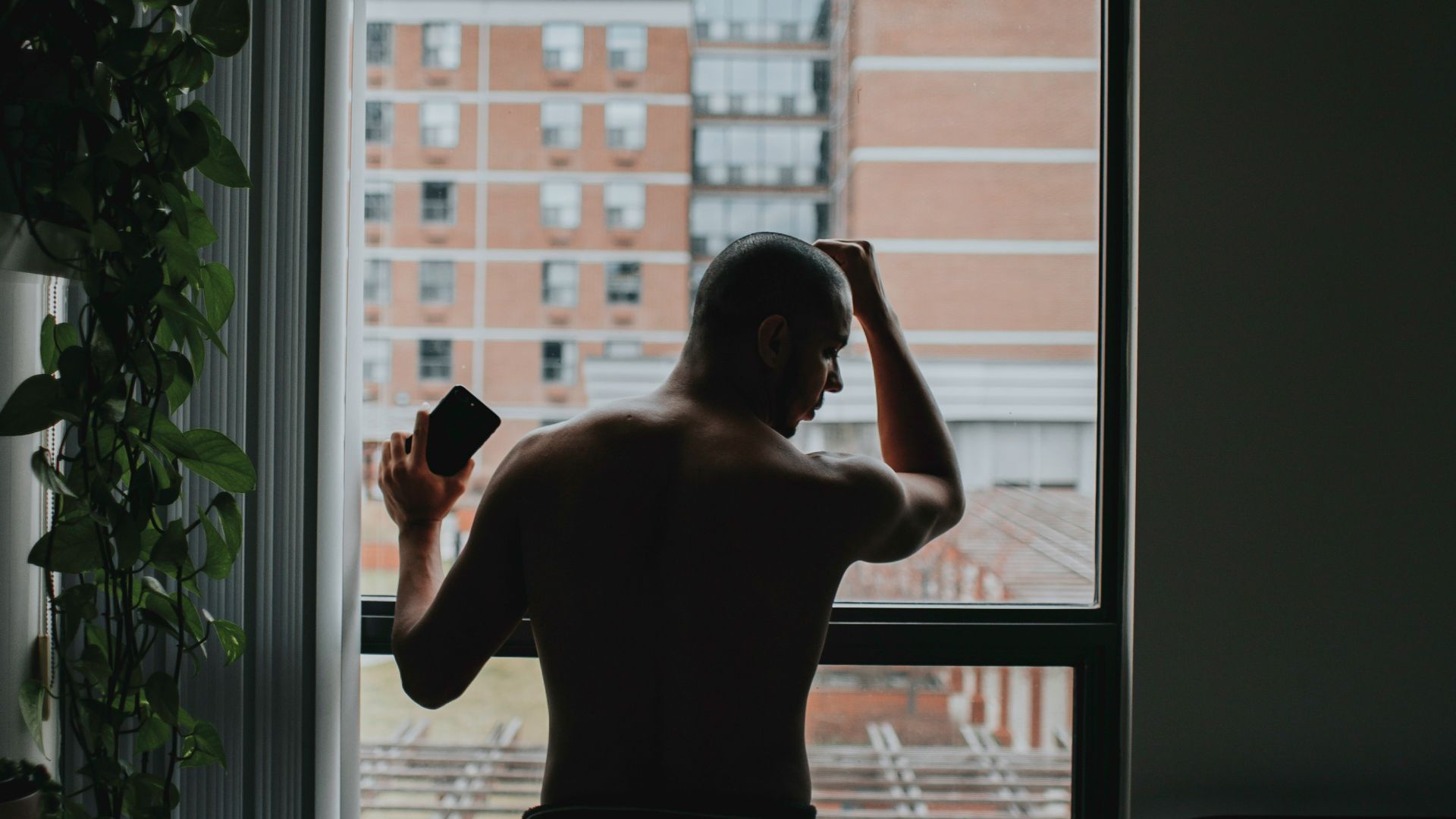 man standing by the window beside bed