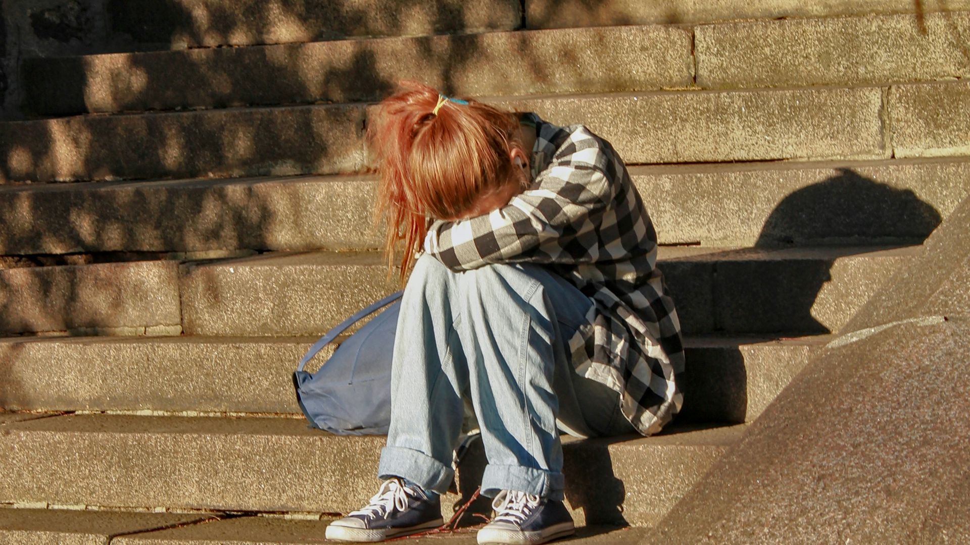 woman in black and white dress sitting on concrete stairs