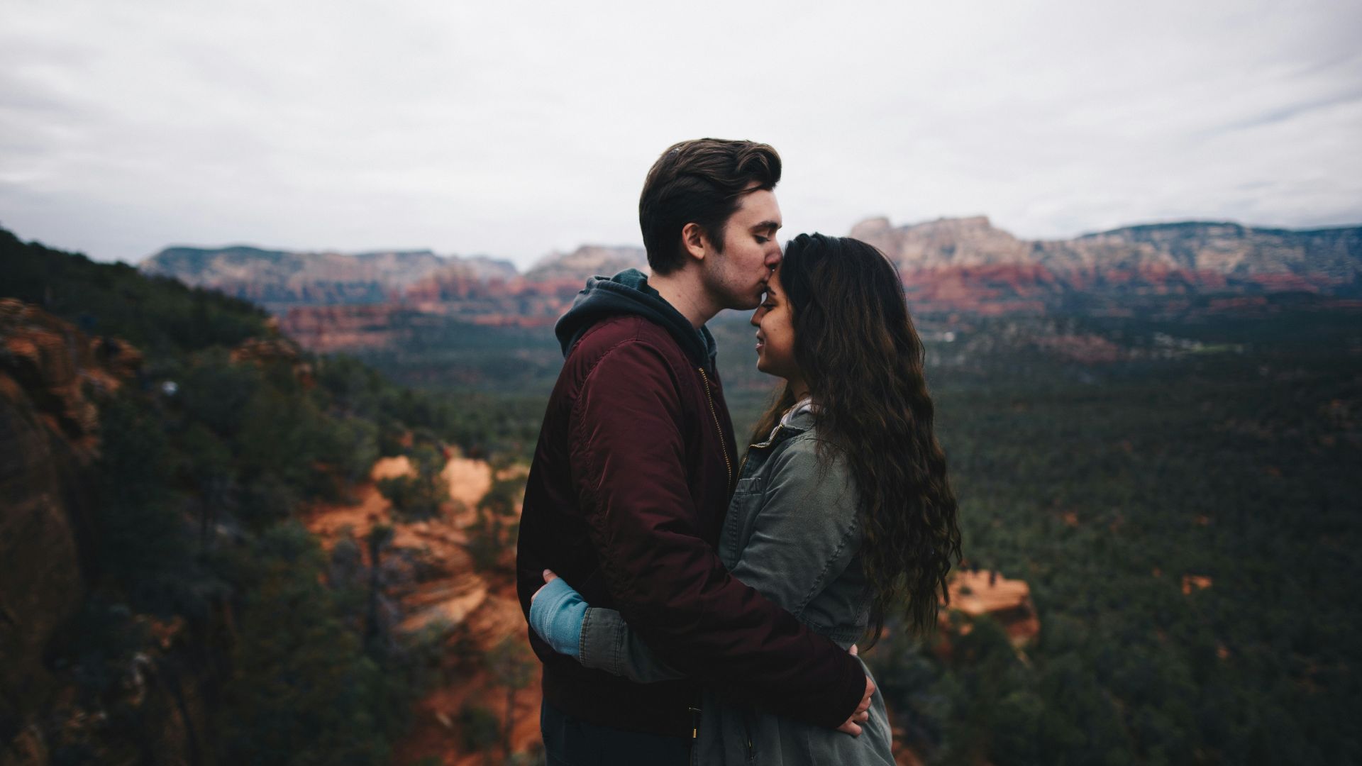 man kissing woman's forehead