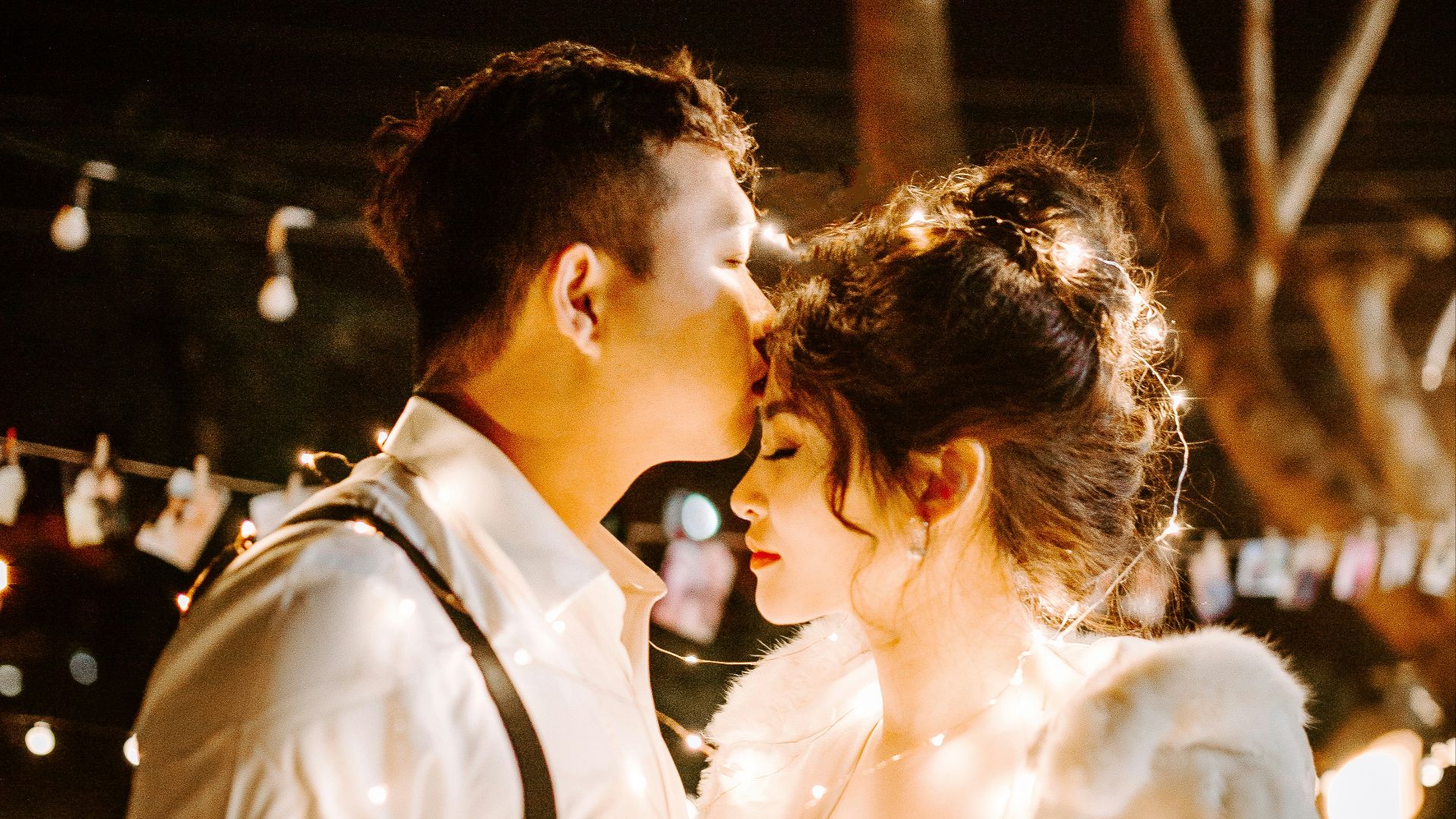 man kissing woman's forehead