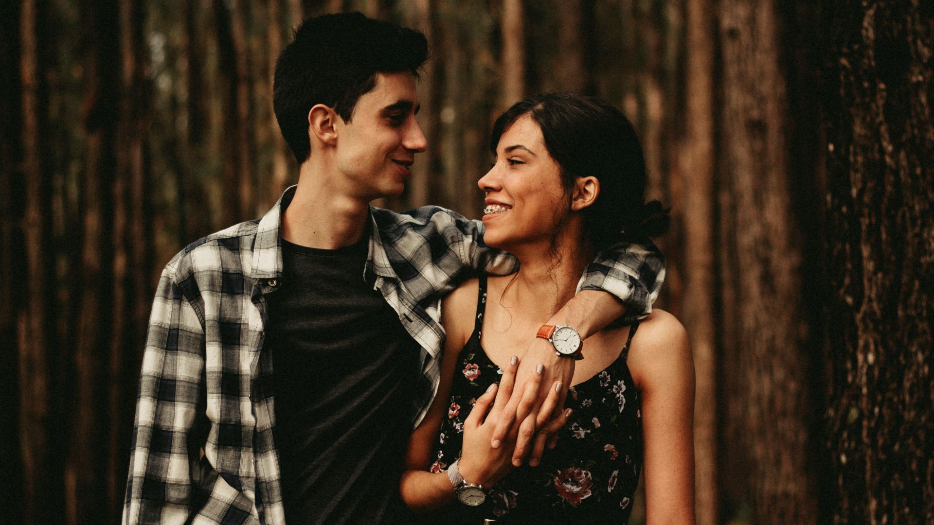 man wrapping arm on woman facing each other