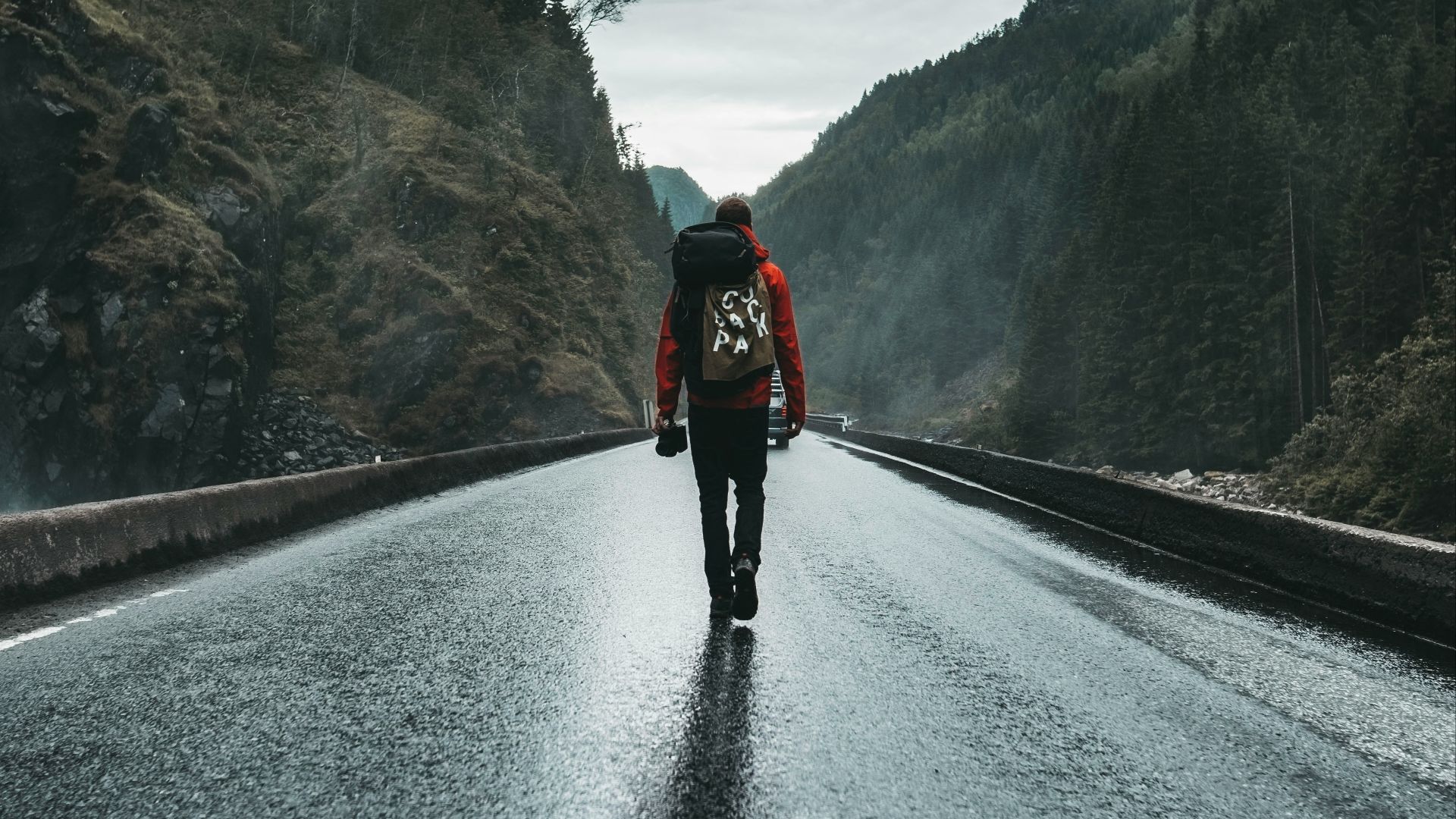 person in black jacket and black pants walking on road during daytime