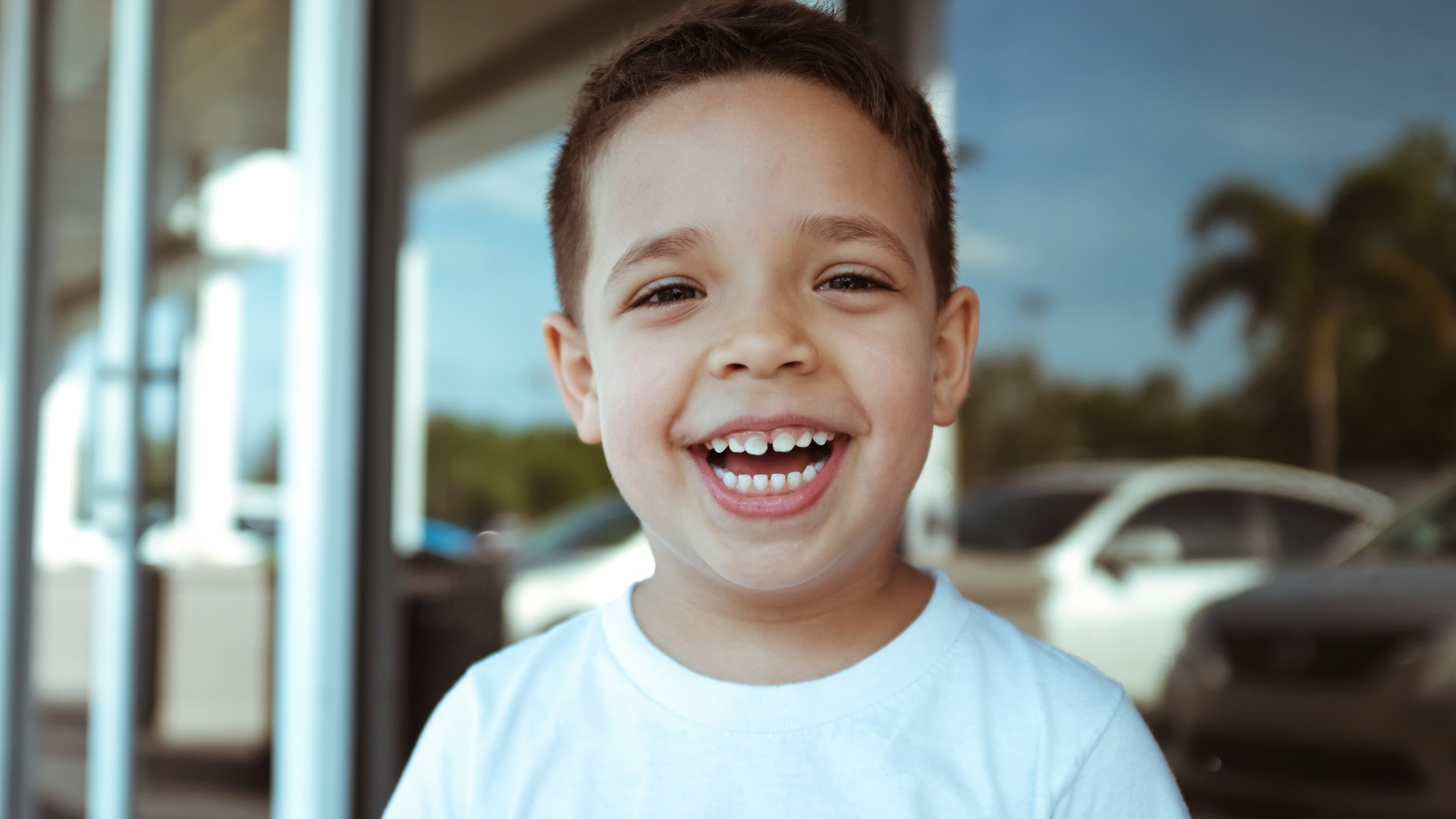 smiling boy wearing white crew-neck t-shirt during daytime