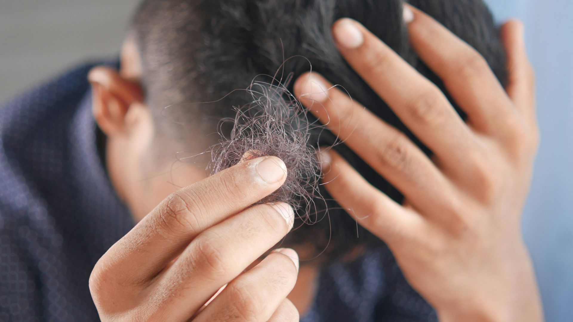 a man is combing his hair with his hands