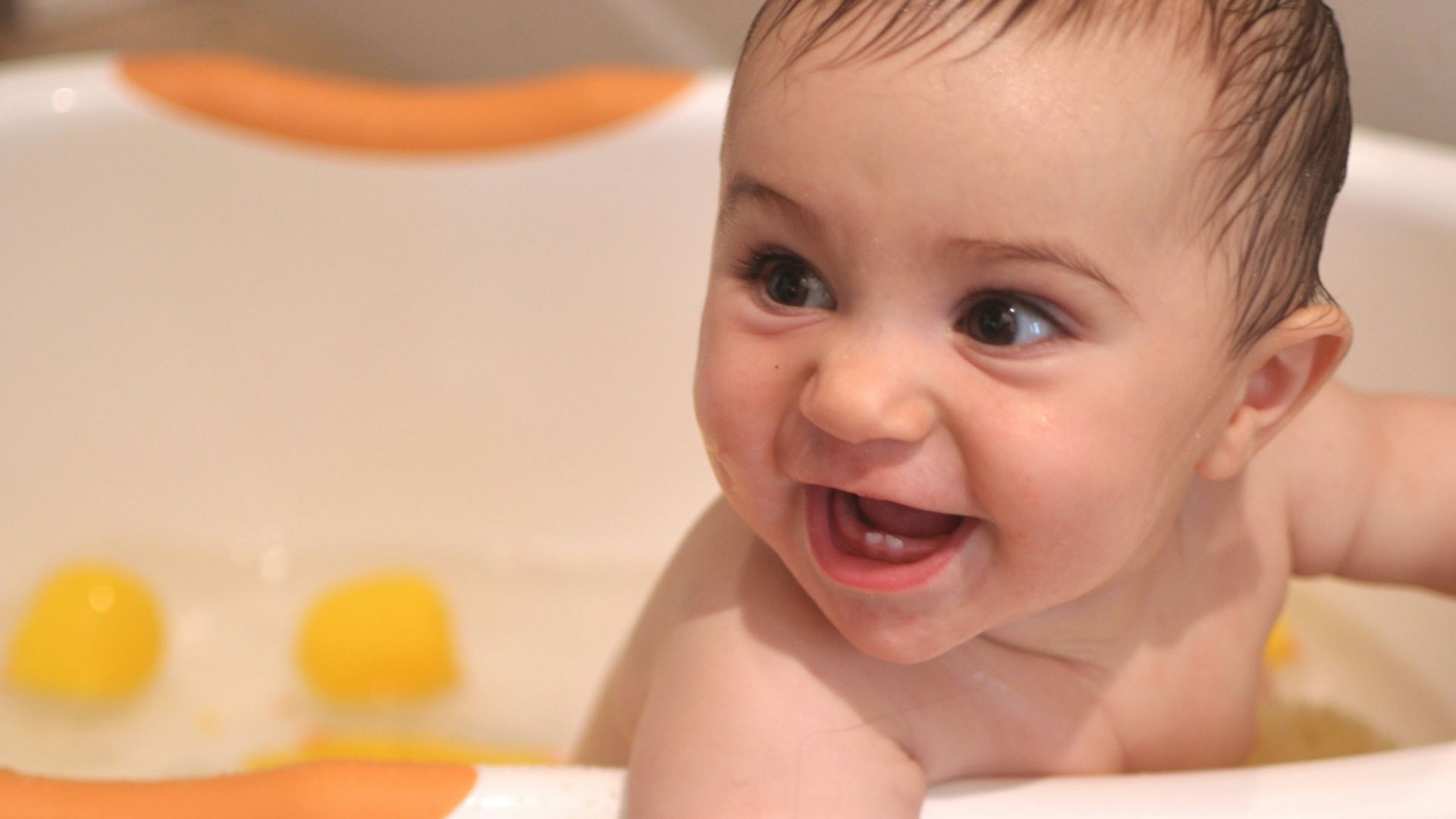 baby in white bathtub with yellow liquid