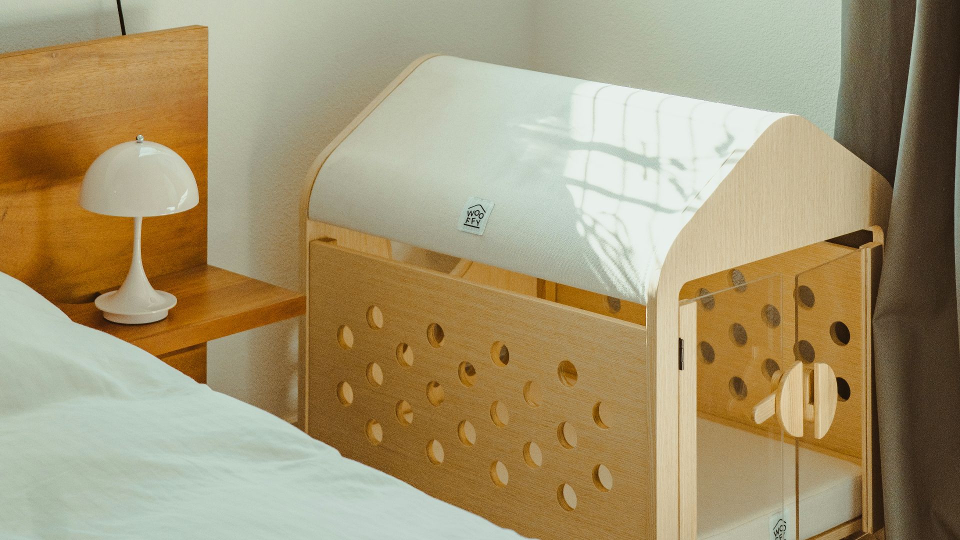 Wooden baby crib next to a bed in a room.