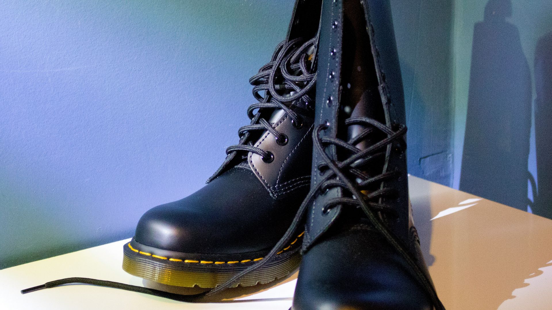 Black dr. martens boots are on a white surface.
