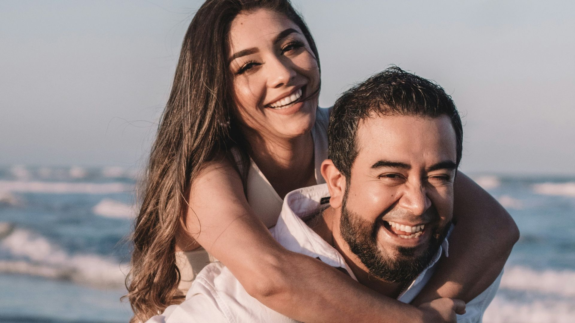 man in white dress shirt hugging woman in white dress