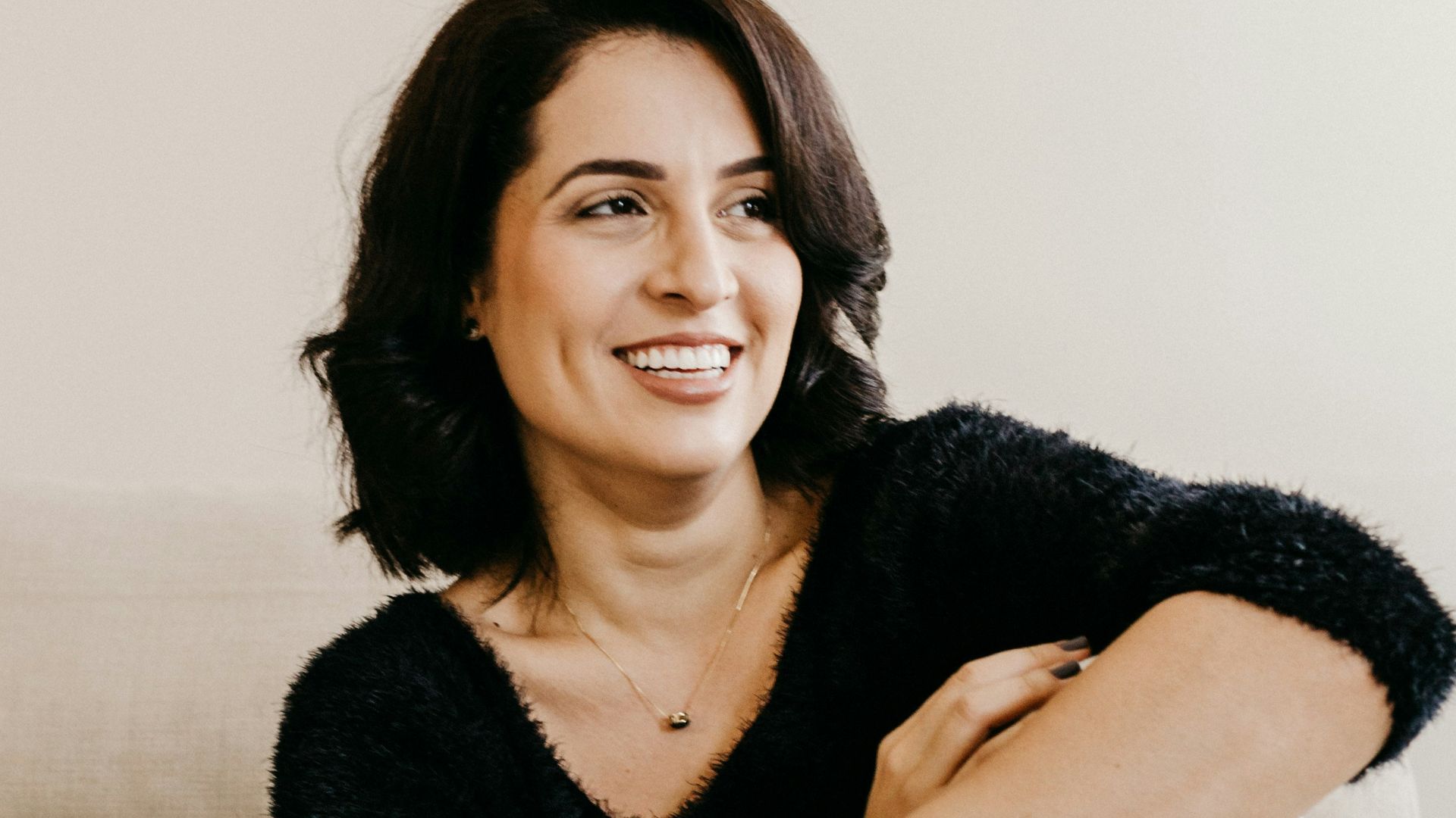 woman in black long sleeve shirt sitting on white couch