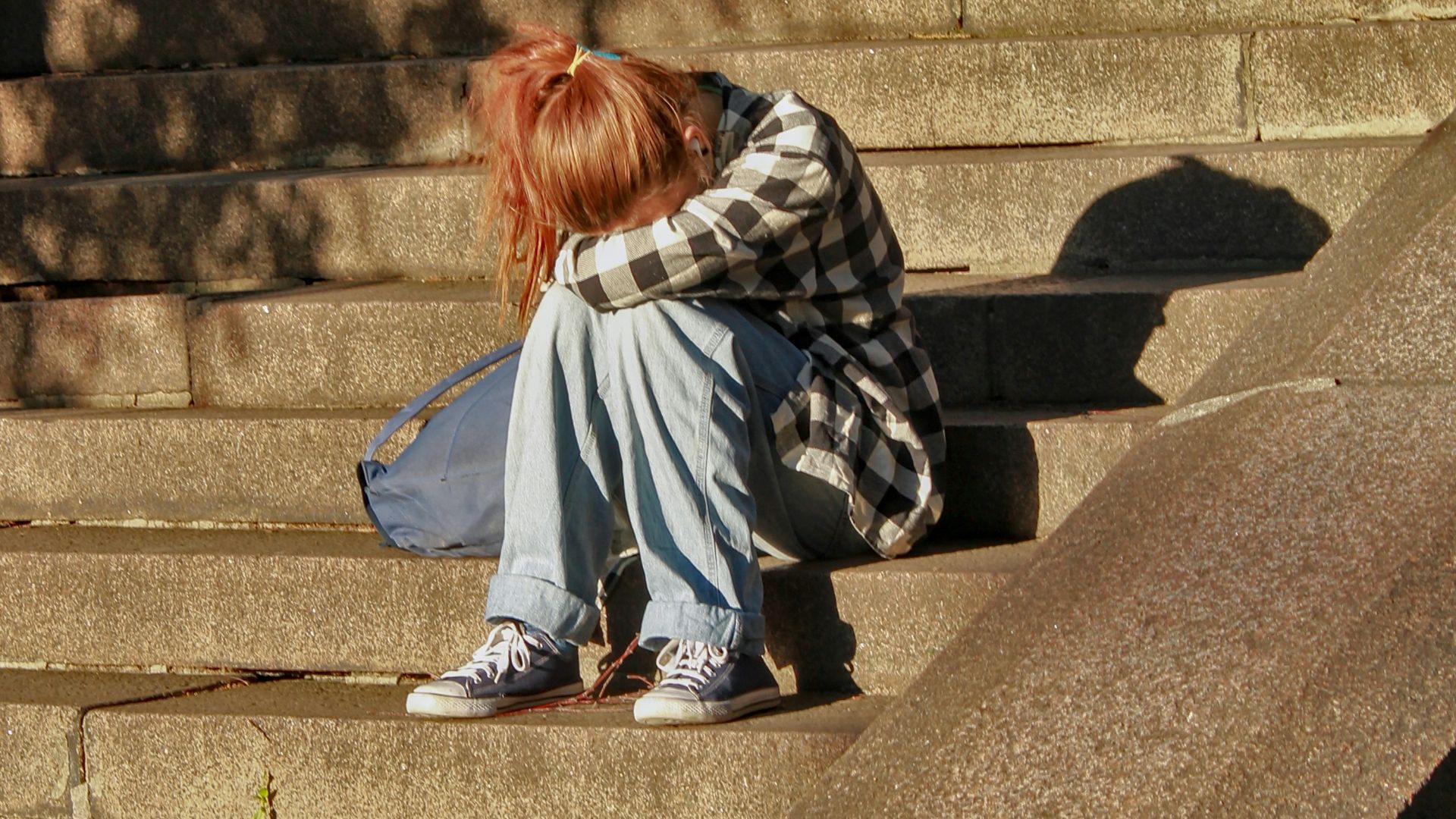 woman in black and white dress sitting on concrete stairs