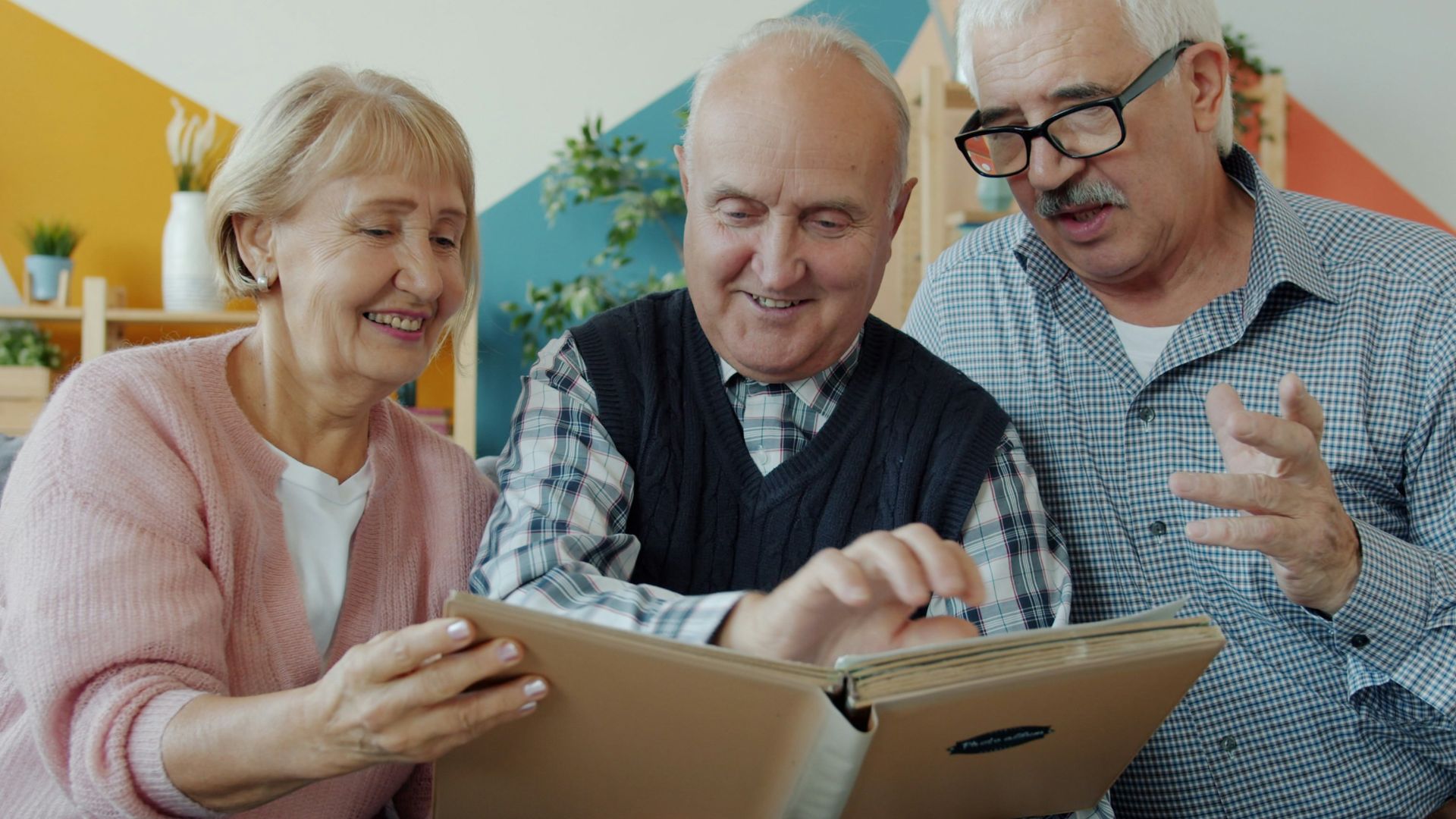 Three seniors looking at a photo album together