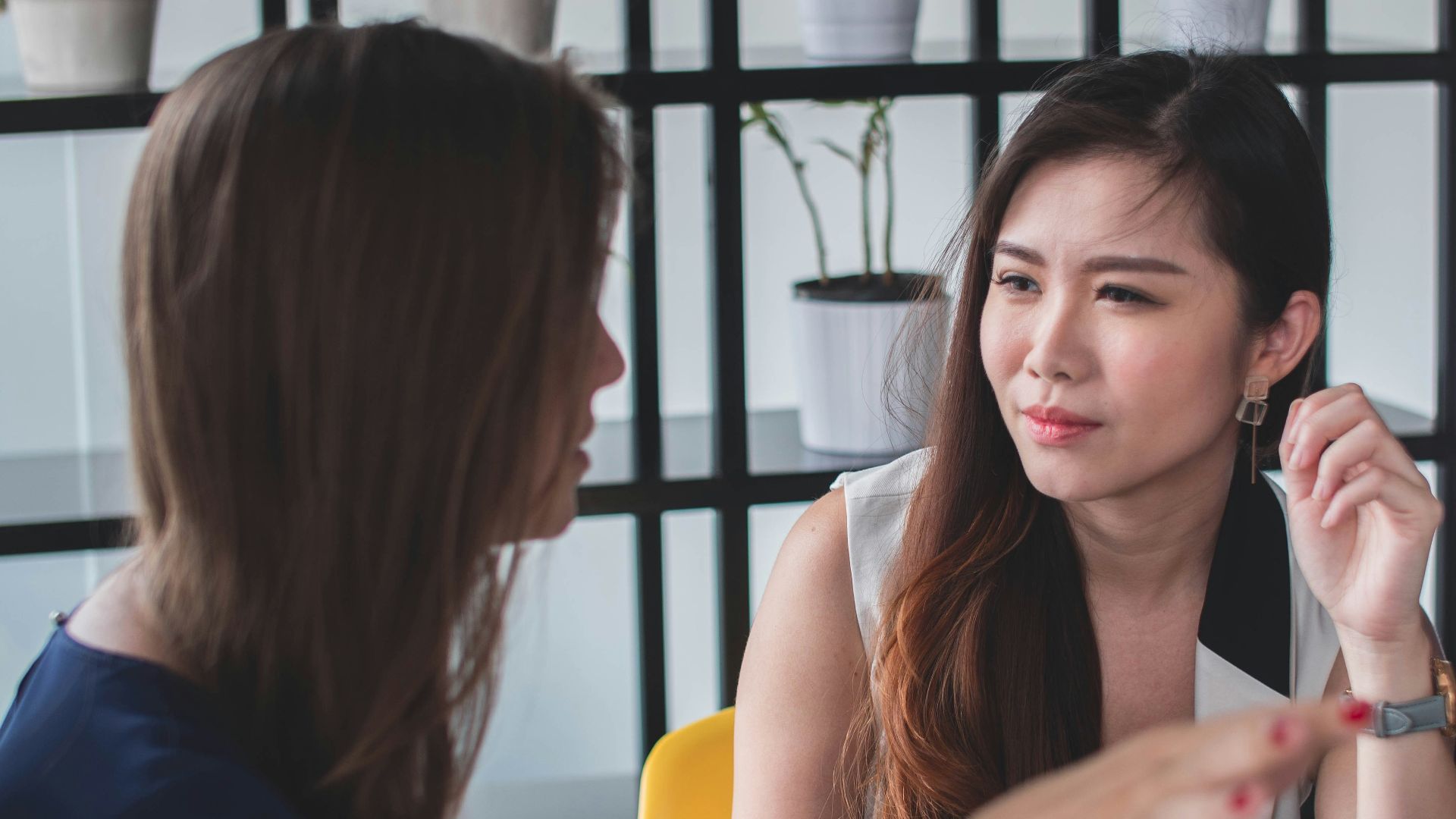 woman sitting on yellow armless chair near gray laptop computer