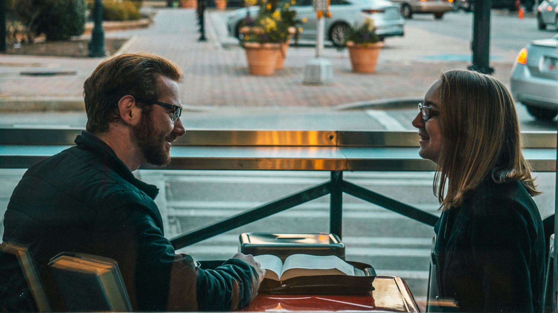 man and woman sitting while talking during daytime