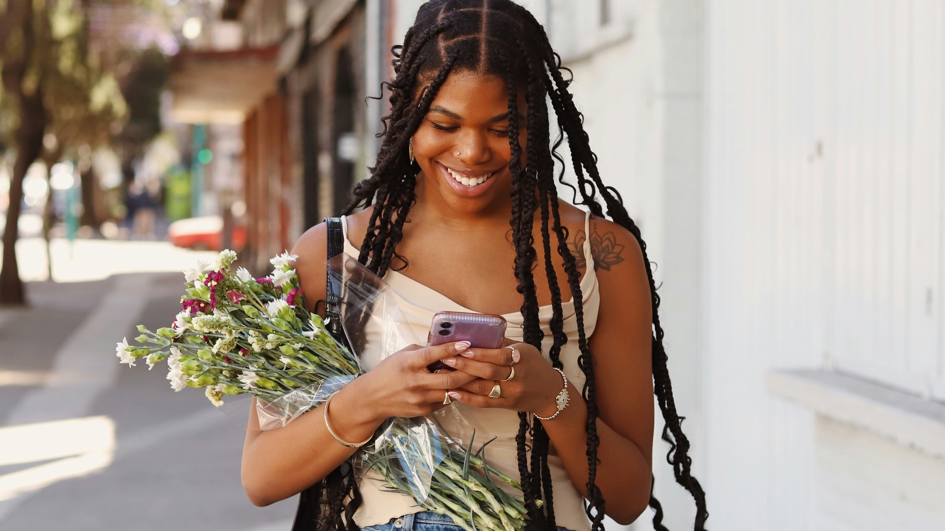 a woman walking down the street looking at her cell phone