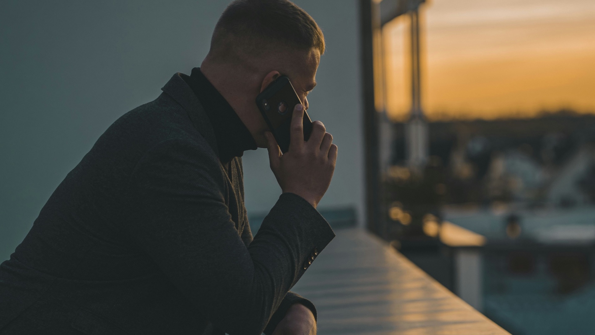 man in black long sleeve shirt sitting by the table
