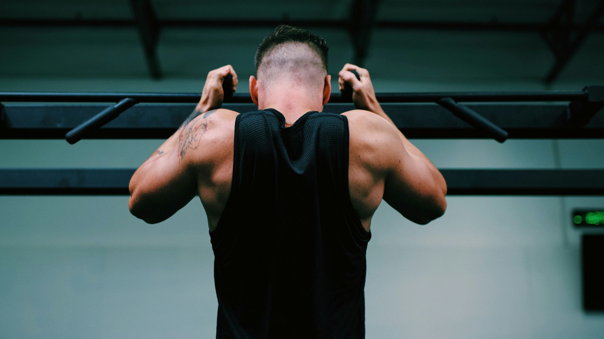 man in black tank top raising his hands