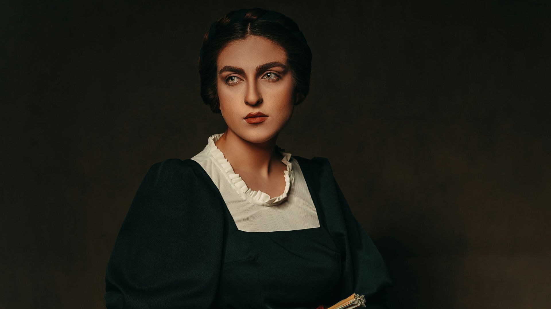 woman in black blazer sitting on brown wooden chair