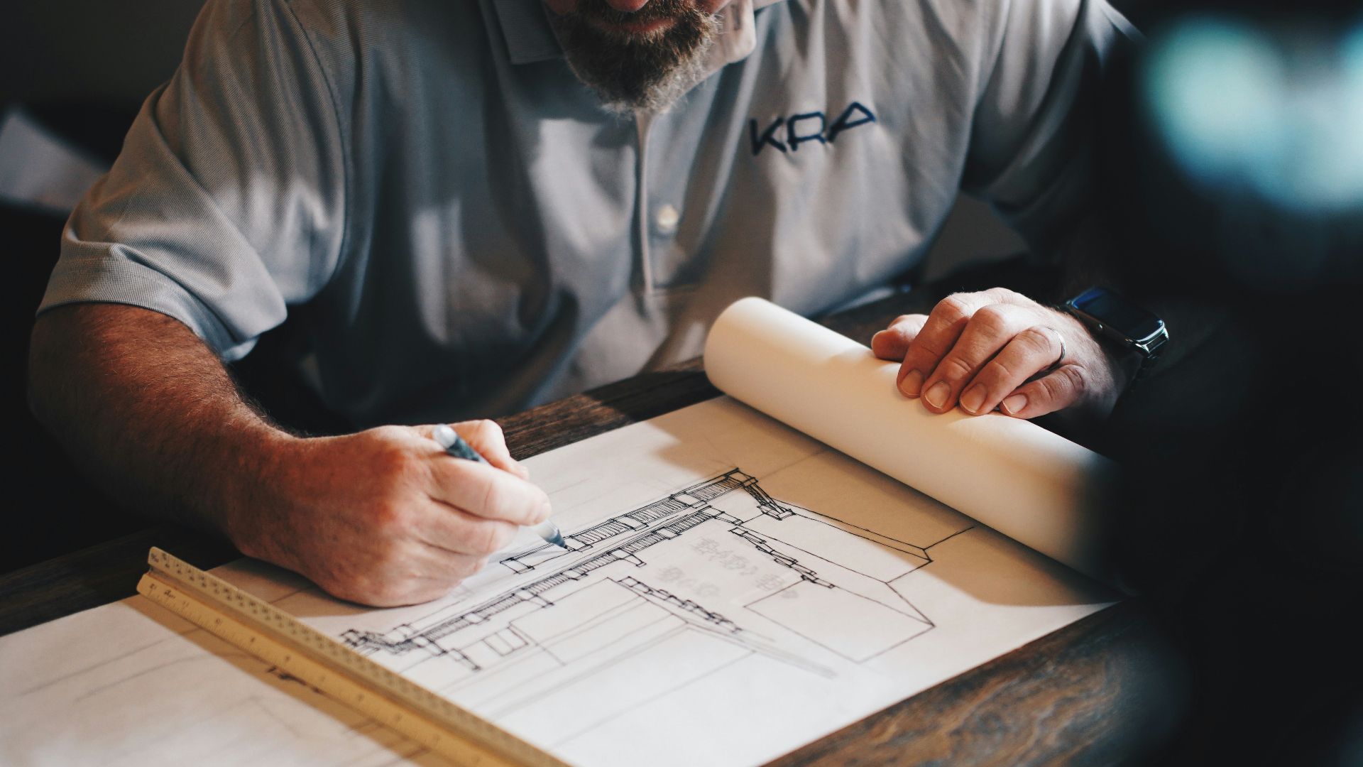 An architect working on a draft with a pencil and ruler