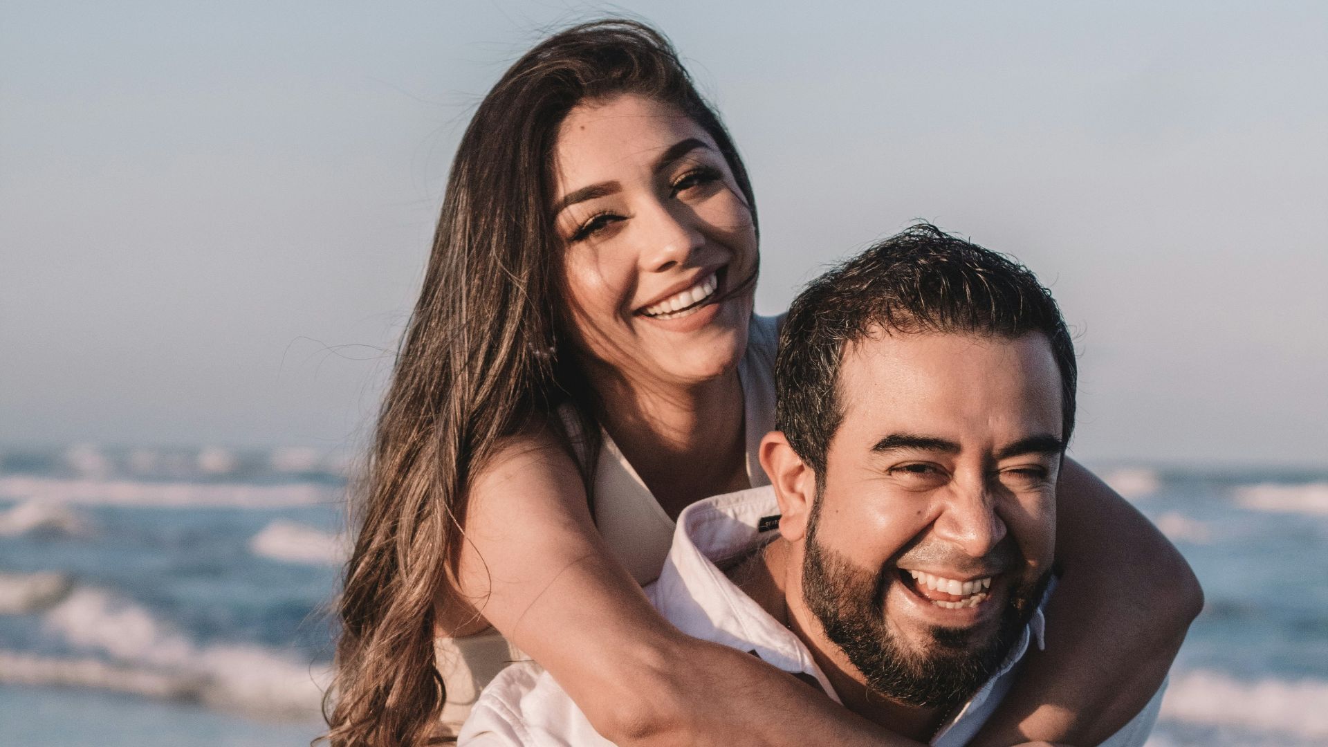 man in white dress shirt hugging woman in white dress