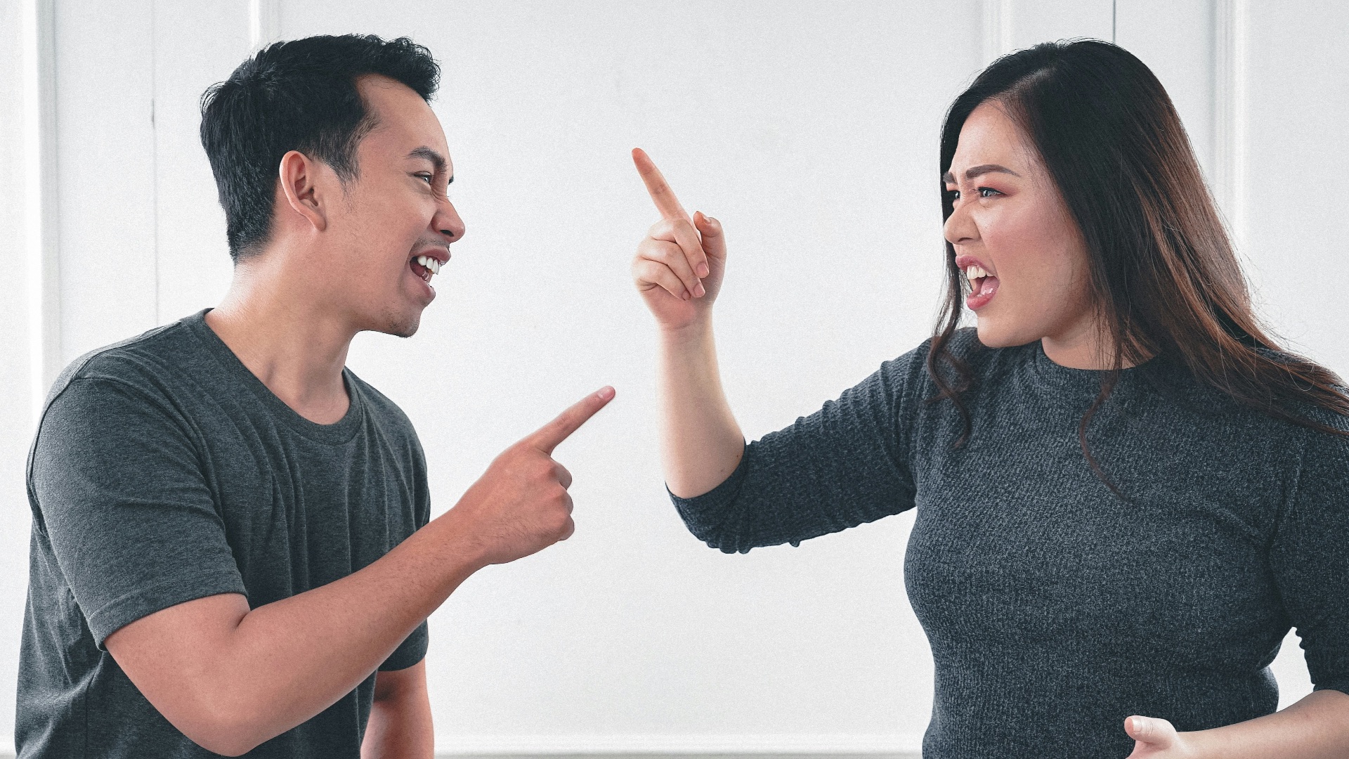 man in gray crew neck long sleeve shirt standing beside woman in black crew neck shirt