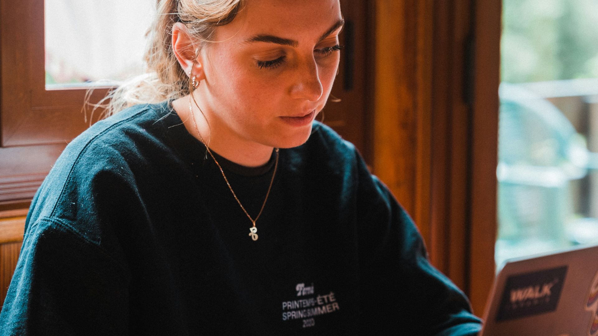 woman in blue sweater using tablet computer