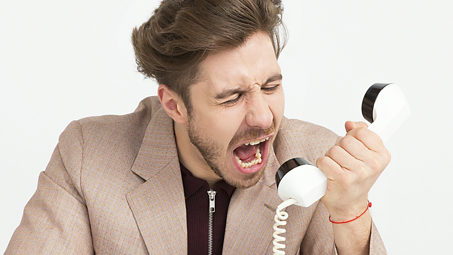 man holding telephone screaming