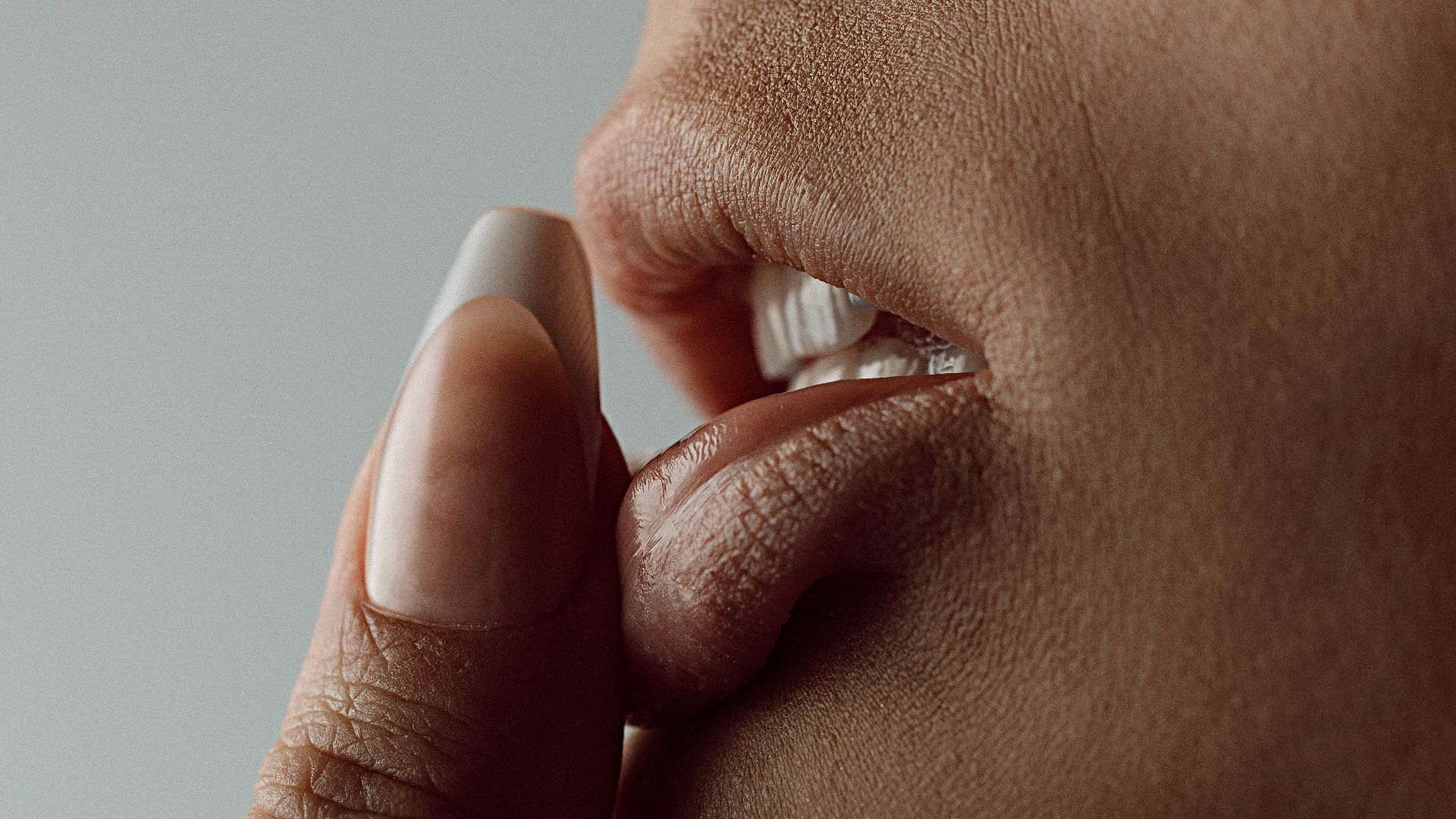 a close up of a person putting something in their mouth