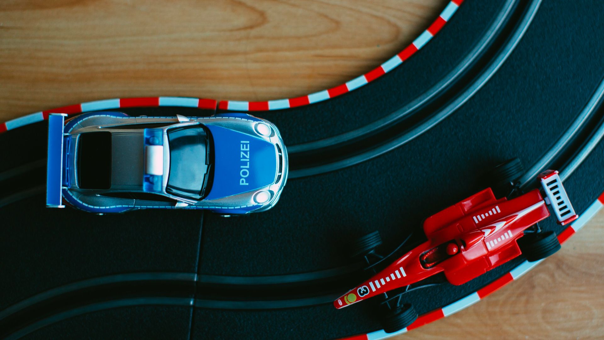 blue toy car beside red formula one toy