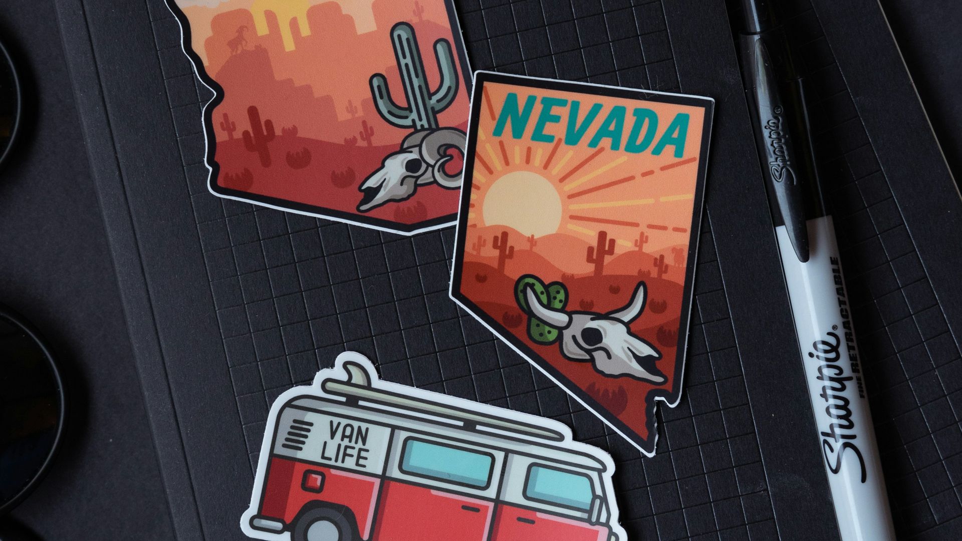 white and black pen beside black and white pen