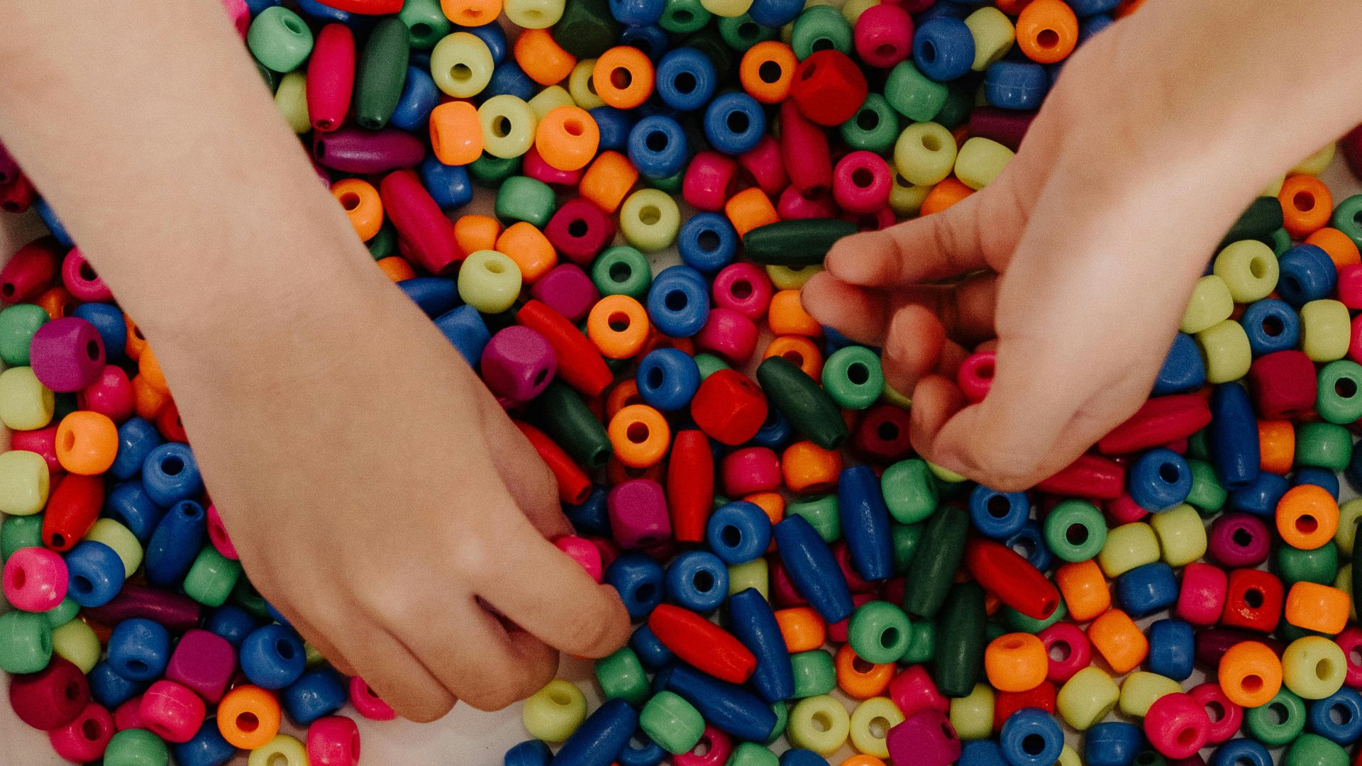 A person holding a bunch of beads in their hands