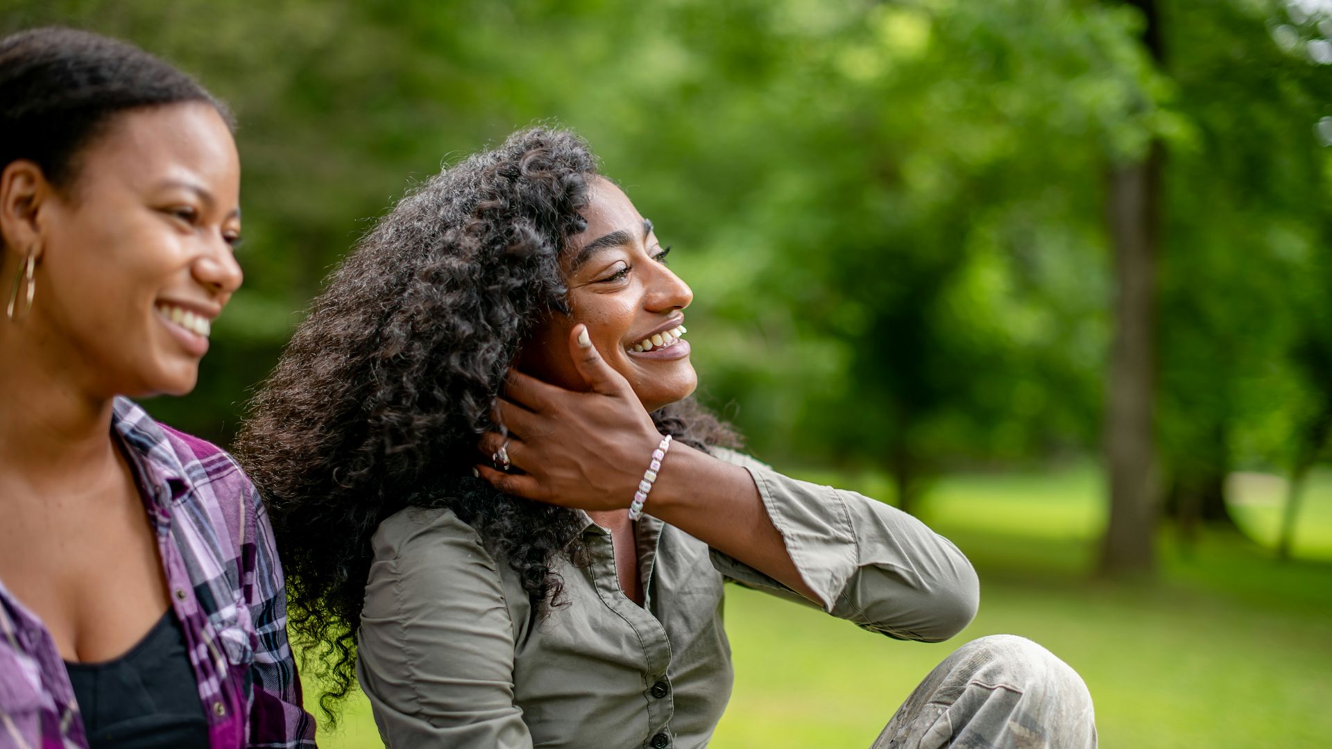 Two smiling women in a park