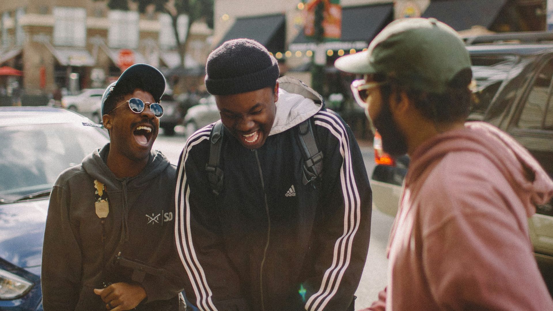 three men in jacket laughing at each other