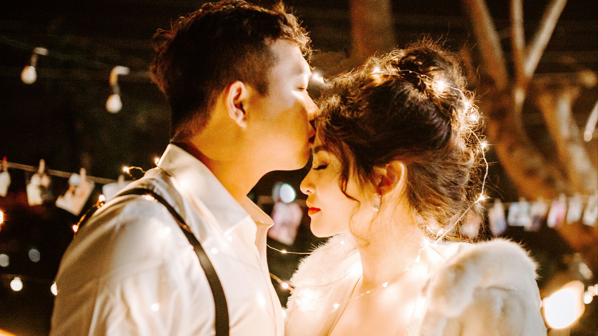 man kissing woman's forehead