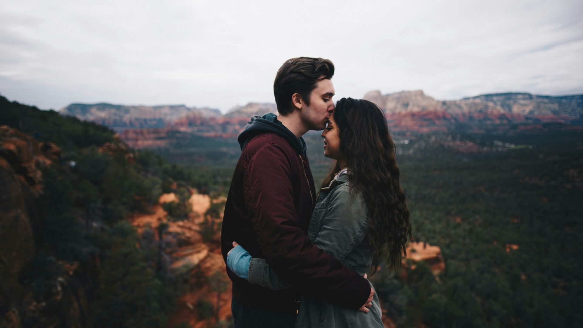 man kissing woman's forehead