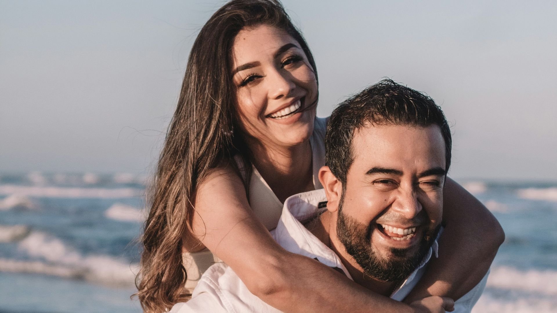 man in white dress shirt hugging woman in white dress