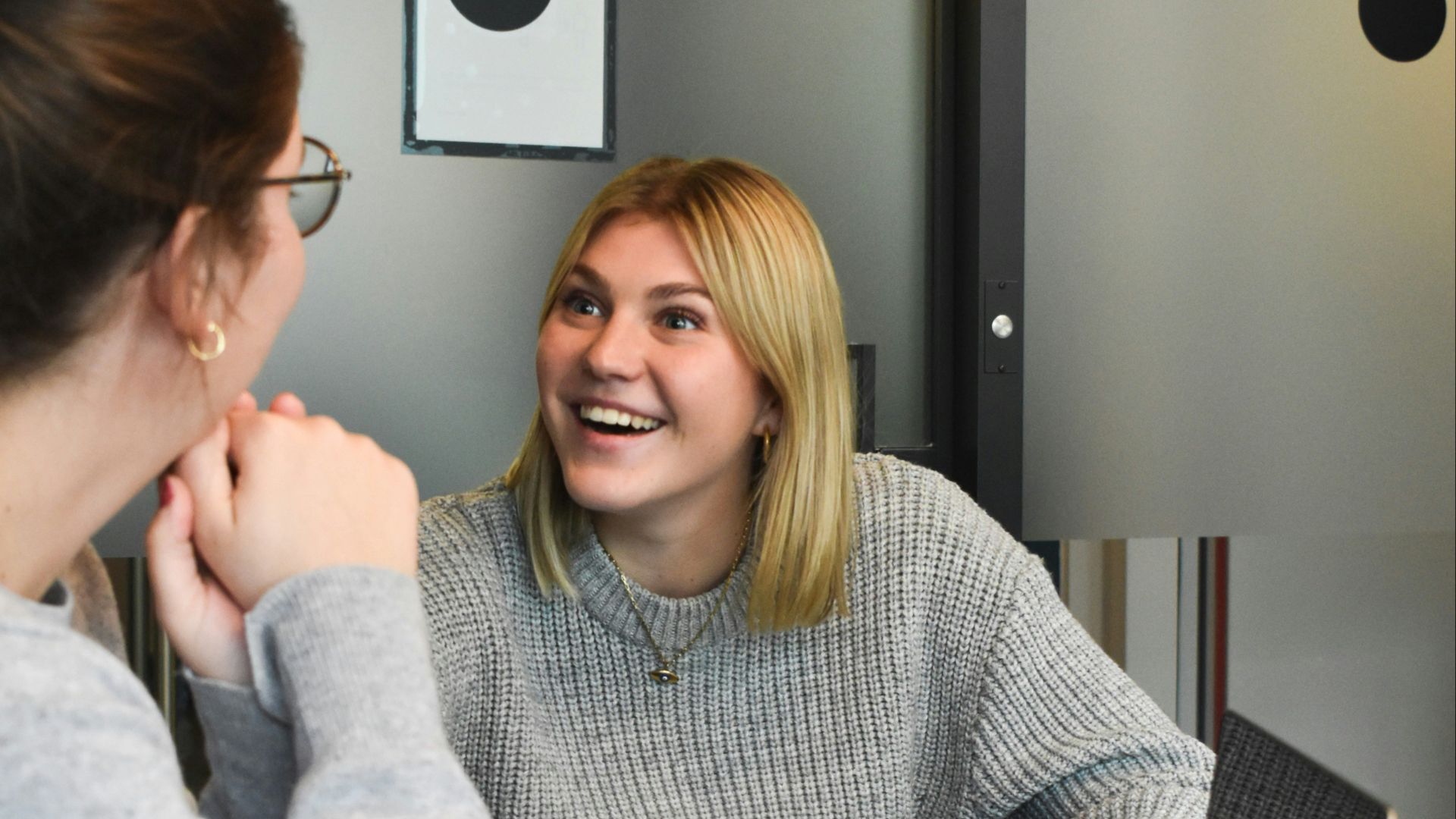 woman in gray sweater sitting beside woman in gray sweater