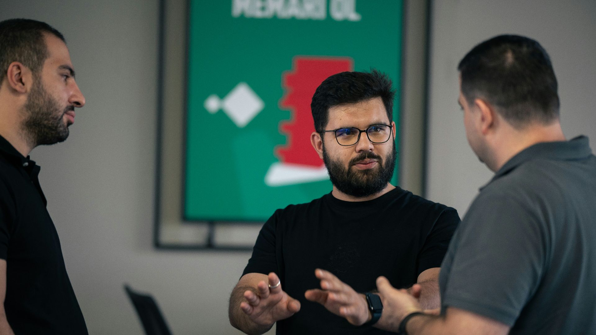 A group of men standing around each other in a room