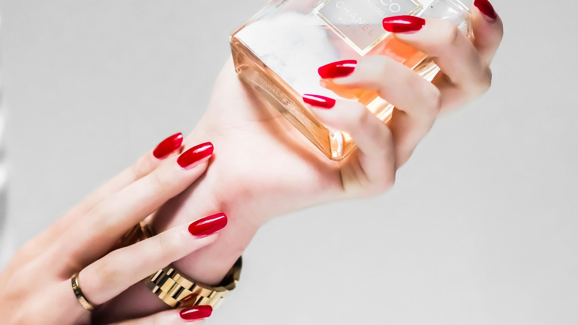 person holding clear glass bottle