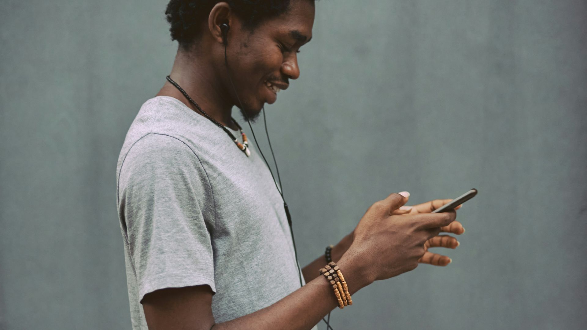 man in white crew neck t-shirt holding smartphone