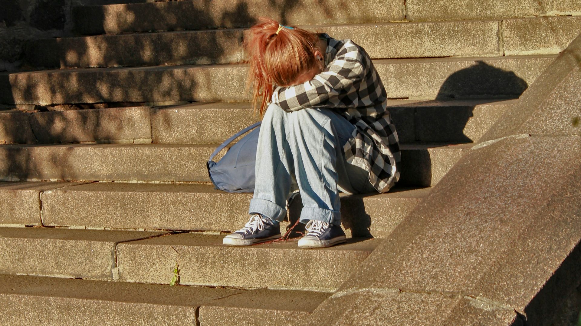 woman in black and white dress sitting on concrete stairs