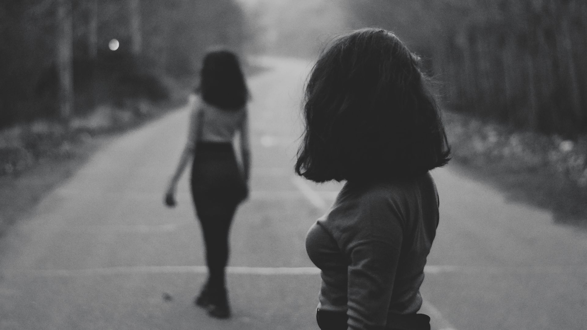woman in black jacket walking on road during daytime
