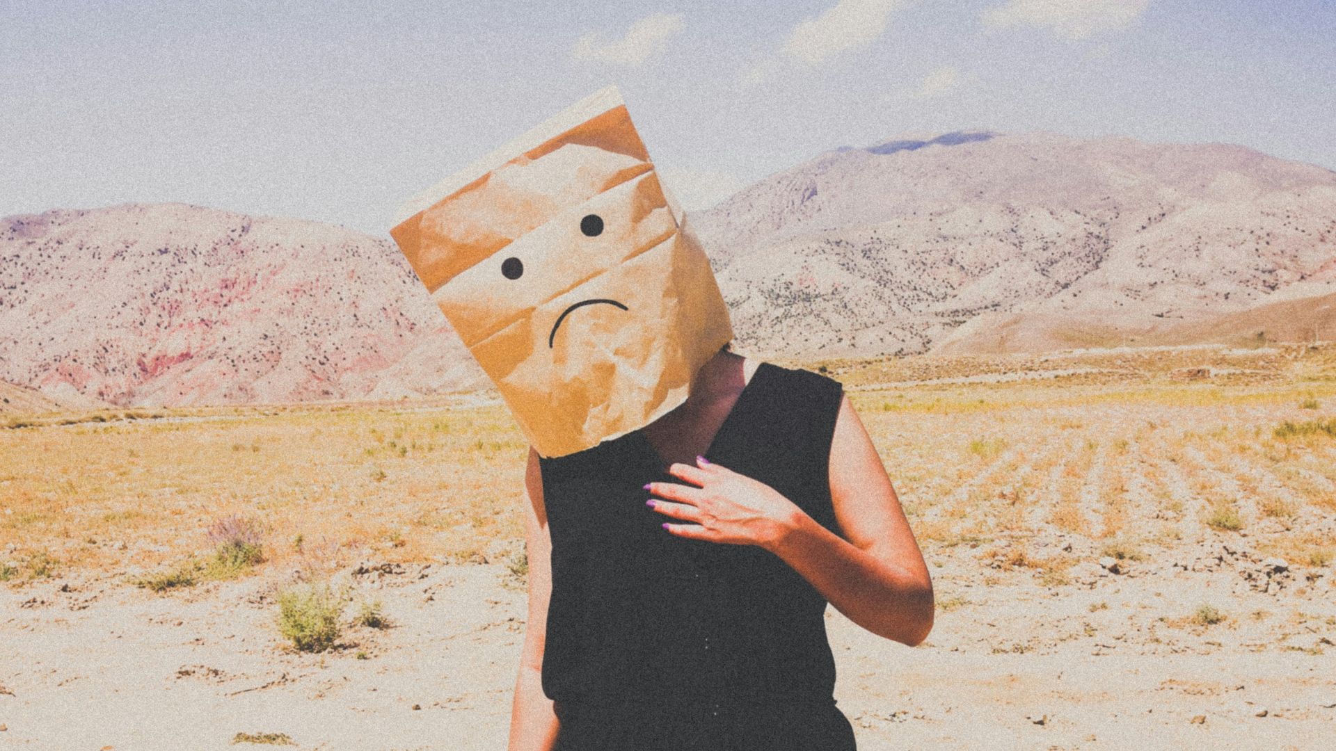 woman in black dress holding brown paper bag