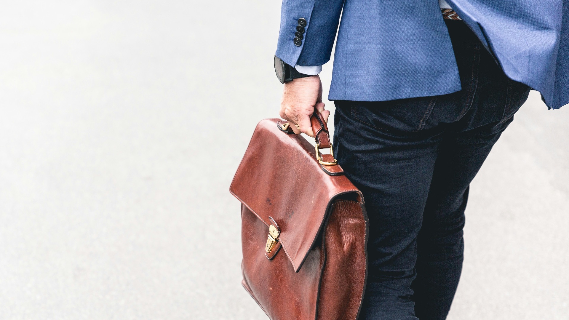 person walking holding brown leather bag