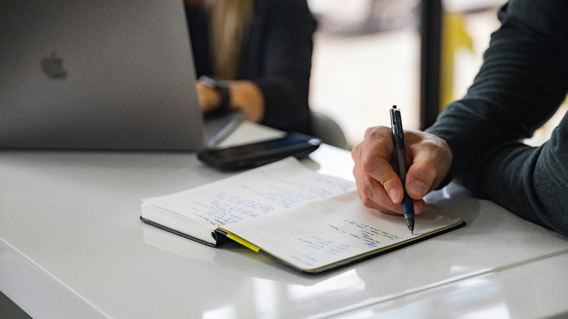 person writing on white paper