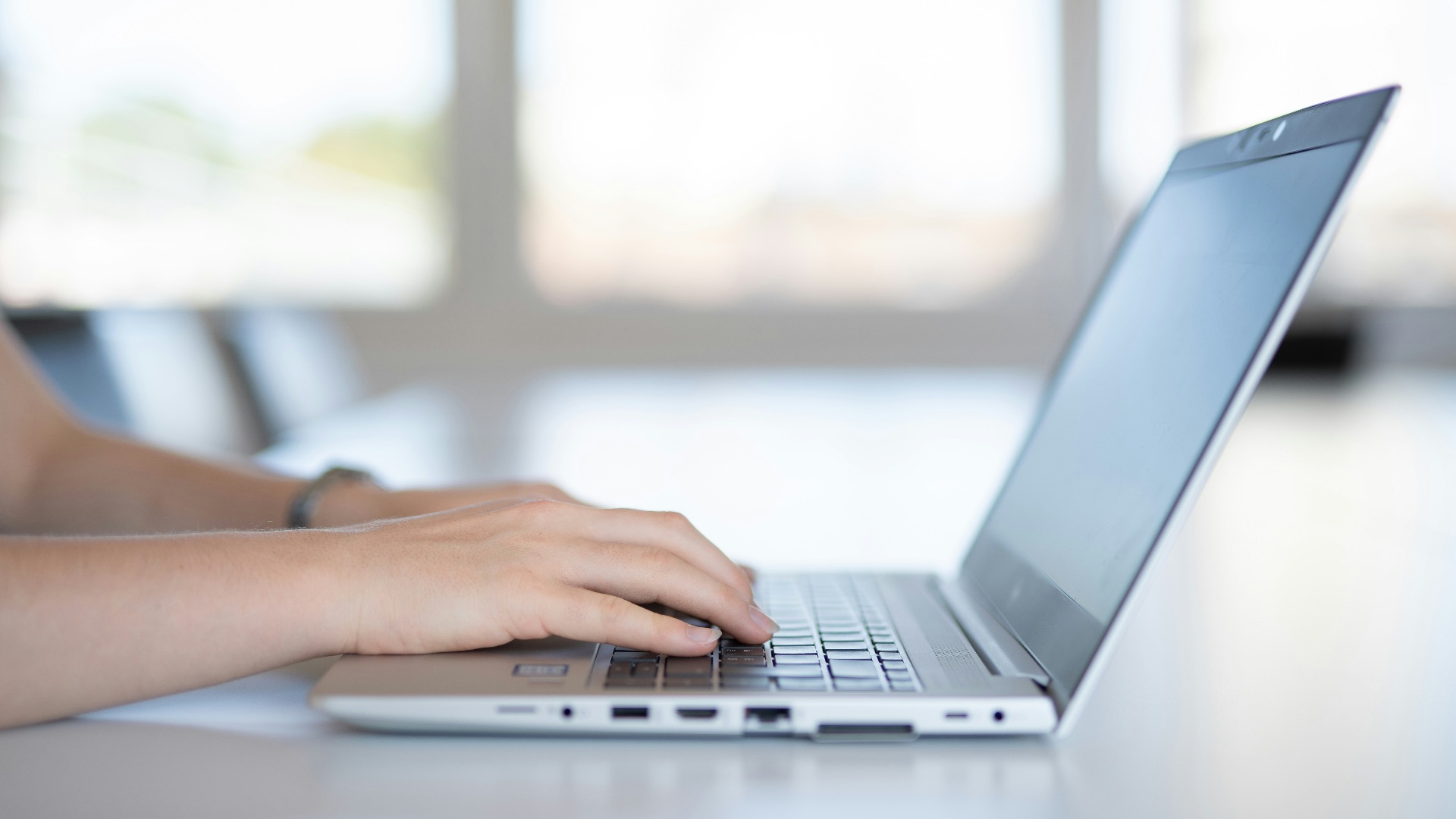 a close up of a person typing on a laptop