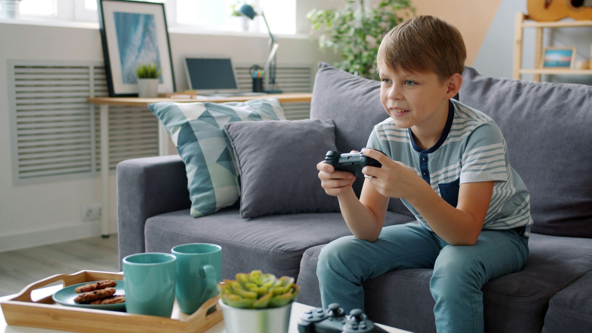Young boy playing video games on couch